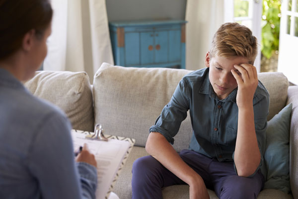 A young boy talking to a therapist